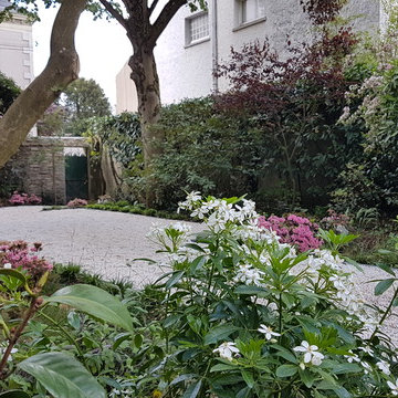 vue sur la terrasse du jardin et ses massifs de terre de bruyère au printemps