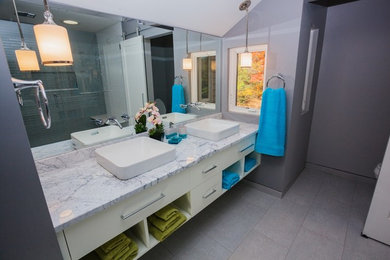 Inspiration for a contemporary beige tile and subway tile porcelain tile and beige floor bathroom remodel in Boston with flat-panel cabinets, white cabinets, a two-piece toilet, beige walls, a vessel sink, quartzite countertops and a hinged shower door