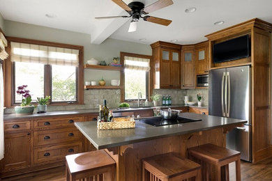 Kitchen - craftsman dark wood floor and brown floor kitchen idea in Minneapolis with an undermount sink, recessed-panel cabinets, dark wood cabinets, stainless steel appliances and an island
