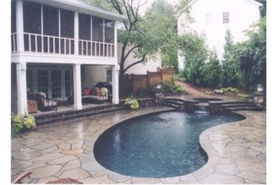 Imagen de jardín ecléctico de tamaño medio en patio trasero con fuente, exposición parcial al sol y adoquines de piedra natural