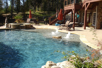 Inspiration for a large mediterranean backyard custom-shaped pool in Atlanta with a hot tub and brick pavers.