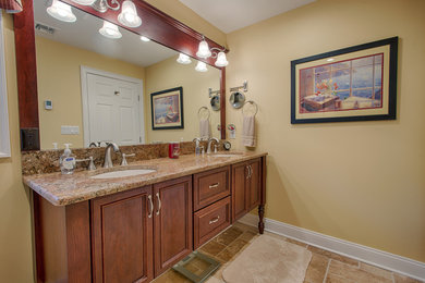 Photo of a mid-sized traditional kids bathroom in Other with furniture-like cabinets, medium wood cabinets, beige walls, ceramic floors, an undermount sink and beige floor.