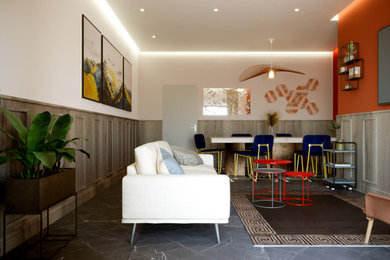 Esempio di un soggiorno classico di medie dimensioni con sala formale, pareti arancioni, pavimento in gres porcellanato, TV a parete, pavimento grigio, soffitto ribassato, boiserie e con abbinamento di mobili antichi e moderni