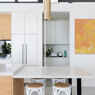 Свежая идея для дизайна: кухня в современном стиле с кладовкой, накладной раковиной, светлыми деревянными фасадами, черной техникой, полом из цементной плитки, двумя и более островами, серым полом, плоскими фасадами, мраморной столешницей, фартуком из зеркальной плитки и разноцветной столешницей - отличное фото интерьера