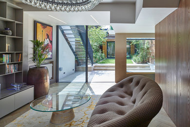 Photo of a medium sized contemporary open plan living room in London with a home bar, multi-coloured walls, light hardwood flooring, a built-in media unit and brown floors.