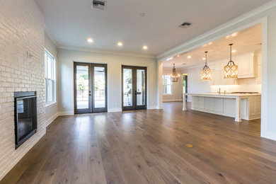 Living room - mid-sized contemporary open concept medium tone wood floor living room idea in Orlando with white walls, a standard fireplace and a brick fireplace