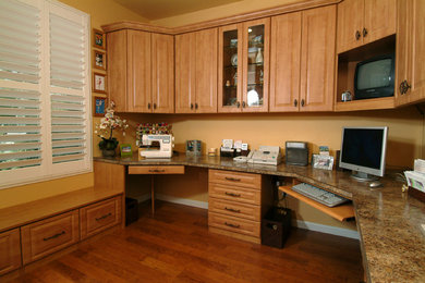 Mid-sized elegant built-in desk light wood floor and brown floor study room photo in Sacramento with beige walls