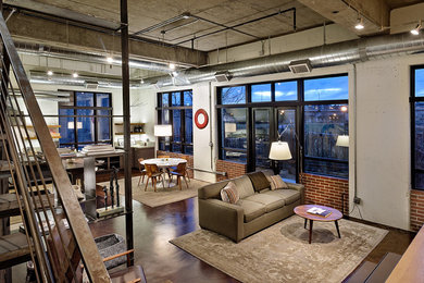 Inspiration for an industrial open concept living room in Denver with concrete floors.