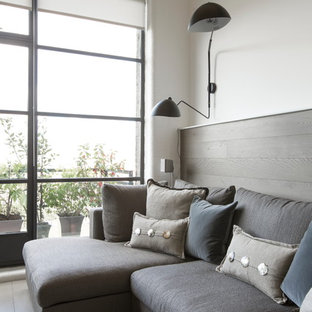 Photo of a medium sized industrial open plan living room in London with white walls, light hardwood flooring and a built-in media unit.
