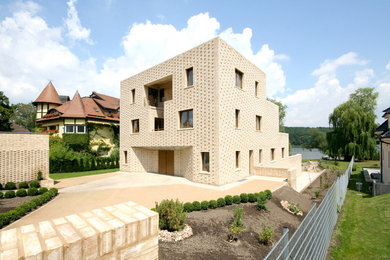 Großes, Dreistöckiges Mediterranes Haus mit Backsteinfassade, Flachdach und beiger Fassadenfarbe in Berlin