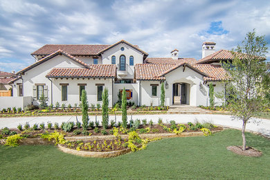 This is an example of a large mediterranean two-storey stucco white exterior in Dallas with a gable roof.