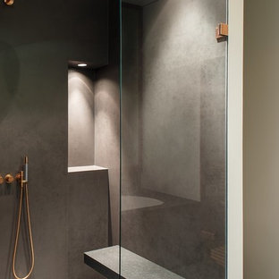 Cette image montre une grande salle d'eau design avec une douche à l'italienne, un mur gris, un carrelage gris, un placard à porte plane, des portes de placard blanches, une baignoire posée, un WC séparé, du carrelage en pierre calcaire, un sol en calcaire, une vasque, un plan de toilette en marbre, un sol gris et une cabine de douche à porte battante.