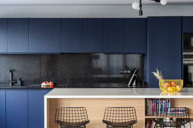 Large contemporary single-wall open plan kitchen in Other with a double-bowl sink, blue cabinets, quartzite benchtops, black splashback, black appliances, ceramic floors, with island, white floor and white benchtop.
