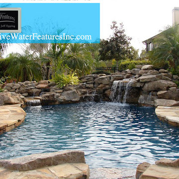 Tropical backyard room with pool waterfall, fireplace, and koi pond