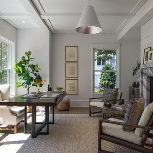 Ejemplo de despacho tradicional renovado con paredes blancas, suelo de madera en tonos medios, marco de chimenea de piedra, escritorio independiente, suelo marrón y chimenea tradicional