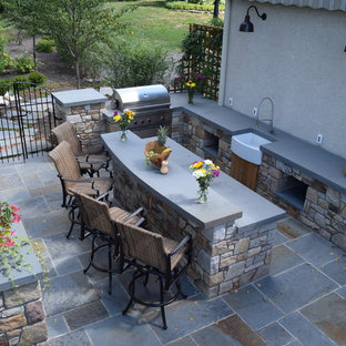 This is an example of a mid-sized arts and crafts backyard patio in Philadelphia with an outdoor kitchen, concrete pavers and no cover.