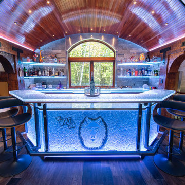 Glass private bar and glass stair treads inside a man cave in Michigan