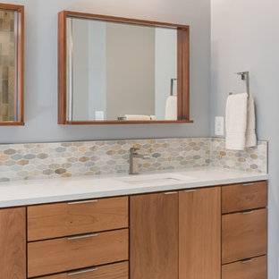 Ispirazione per una stanza da bagno padronale minimalista di medie dimensioni con ante lisce, ante in legno scuro, vasca da incasso, piastrelle blu, piastrelle verdi, piastrelle arancioni, piastrelle bianche, piastrelle di vetro, pareti blu, pavimento in gres porcellanato, lavabo sottopiano e top in quarzite