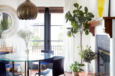 Dining room - small eclectic terra-cotta tile dining room idea in Los Angeles with a standard fireplace and a tile fireplace