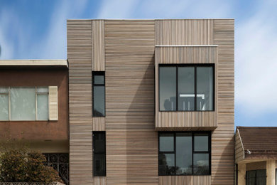 Ejemplo de fachada de casa minimalista de tres plantas con revestimiento de madera
