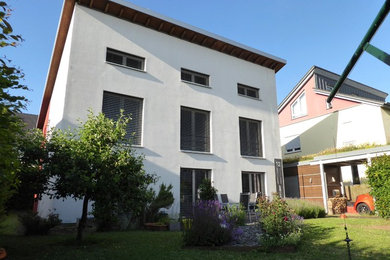 Großes, Zweistöckiges Modernes Einfamilienhaus mit Putzfassade, weißer Fassadenfarbe und Pultdach in Sonstige