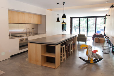 Contemporary single-wall kitchen in Sydney with concrete benchtops, concrete floors and with island.