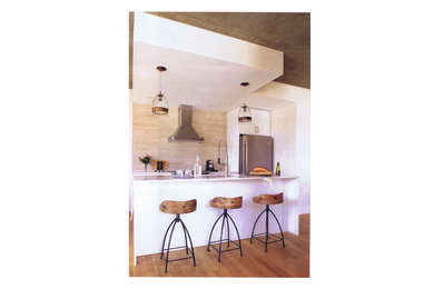Inspiration for a small transitional kitchen remodel in Montreal with flat-panel cabinets, white cabinets, quartzite countertops, beige backsplash, stone tile backsplash and an island