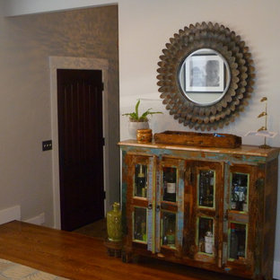 Bild på en stor eklektisk foajé, med grå väggar, mellanmörkt trägolv, en enkeldörr och mörk trädörr