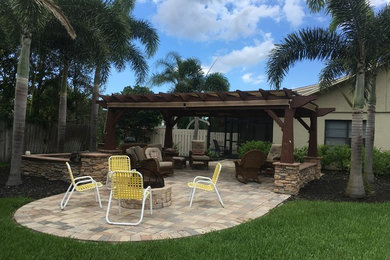 Design ideas for a large traditional backyard patio in Orlando with brick pavers and a pergola.