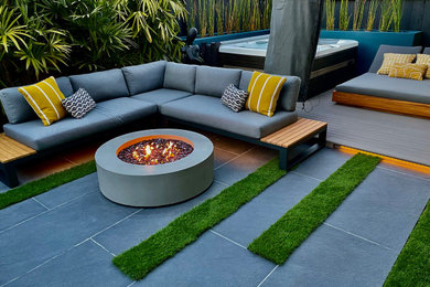 Example of a small mid-century modern backyard concrete paver patio design in San Francisco with a fire pit
