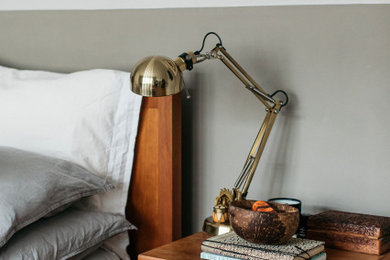 Ejemplo de dormitorio principal retro con paredes grises, suelo de madera en tonos medios y suelo beige