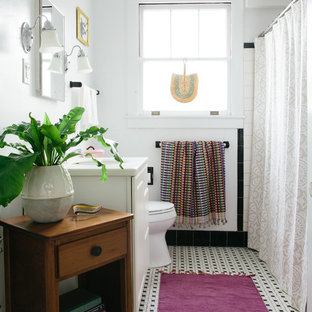 Inspiration for a mid-sized eclectic 3/4 black tile, black and white tile, white tile and porcelain tile porcelain floor and multicolored floor tub/shower combo remodel in New Orleans with furniture-like cabinets, white cabinets, white walls, an undermount sink, solid surface countertops and white countertops