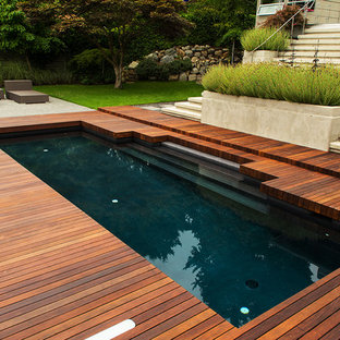 Mittelgroßes Retro Sportbecken hinter dem Haus in rechteckiger Form mit Wasserspiel und Dielen in Vancouver