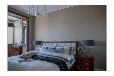 Modelo de dormitorio principal tradicional renovado de tamaño medio con paredes marrones, suelo laminado y suelo marrón