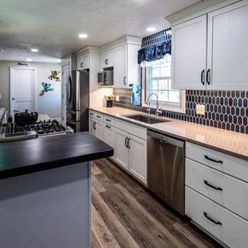 White Kitchen with Blue Tiled Backsplash and Two Tier Island