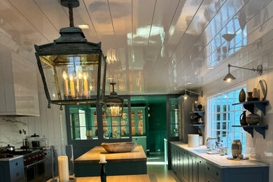 Eat-in kitchen - large traditional medium tone wood floor, white floor and shiplap ceiling eat-in kitchen idea in New York with an integrated sink, flat-panel cabinets, green cabinets, marble countertops, white backsplash, shiplap backsplash, paneled appliances, two islands and white countertops