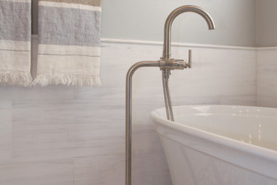 Inspiration for a mid-sized transitional master beige tile and marble tile marble floor and gray floor bathroom remodel in Los Angeles with recessed-panel cabinets, white cabinets, a two-piece toilet, beige walls, a drop-in sink, quartzite countertops, a hinged shower door and beige countertops