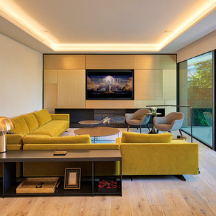 Inspiration för ett funkis separat vardagsrum, med ett finrum, vita väggar, ljust trägolv, en bred öppen spis, en spiselkrans i gips, en inbyggd mediavägg och beiget golv