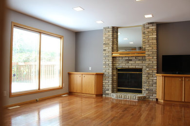 Dining room - traditional medium tone wood floor dining room idea in Other with beige walls, a standard fireplace and a brick fireplace