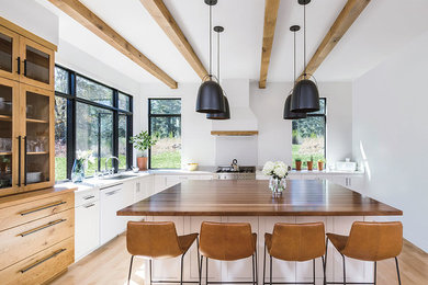 Inspiration for a transitional medium tone wood floor and brown floor kitchen remodel in Denver with an undermount sink, white cabinets, window backsplash, stainless steel appliances, an island and white countertops
