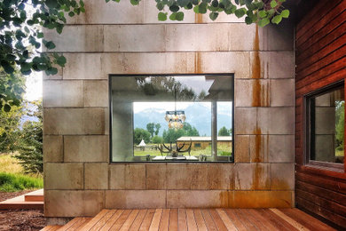 Imagen de fachada de casa gris actual de tamaño medio de dos plantas con revestimiento de metal