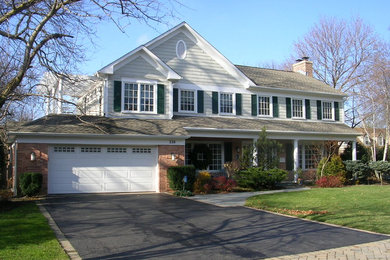 This is an example of a mid-sized traditional two-storey beige exterior in Chicago with concrete fiberboard siding and a gable roof.