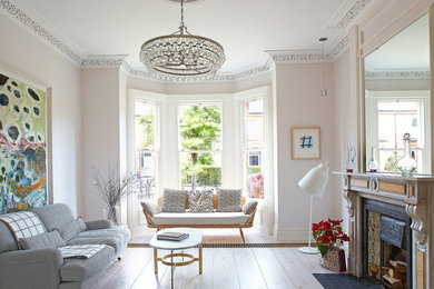 Inspiration for a traditional living room in Dublin with white walls, light hardwood floors, a standard fireplace, a stone fireplace surround and no tv.