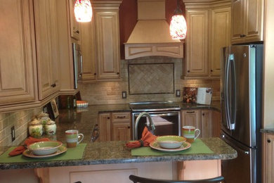 Mid-sized elegant u-shaped light wood floor eat-in kitchen photo in Philadelphia with a double-bowl sink, raised-panel cabinets, light wood cabinets, granite countertops, beige backsplash, subway tile backsplash, stainless steel appliances and a peninsula