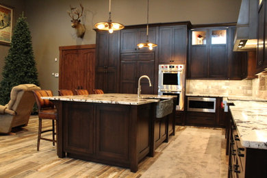 Large traditional l-shaped eat-in kitchen in St Louis with a farmhouse sink, shaker cabinets, dark wood cabinets, granite benchtops, ceramic splashback, panelled appliances and with island.