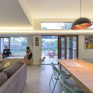 キャンベラの小さいコンテンポラリースタイルのLDKの画像 (白い壁、コンクリートの床、標準型暖炉、レンガの暖炉まわり、グレーの床)