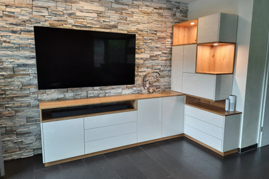 Modelo de sala de estar abierta contemporánea de tamaño medio con paredes beige y televisor en una esquina
