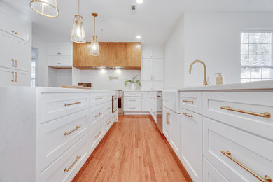 Mid-sized transitional u-shaped brown floor kitchen photo in DC Metro with recessed-panel cabinets, white cabinets, marble countertops, white backsplash, stainless steel appliances, an island and white countertops