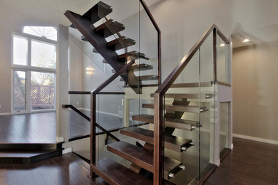 Design ideas for a large modern wood floating staircase in Edmonton with glass railing.