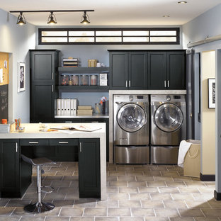 トロントの中サイズのトランジショナルスタイルのおしゃれな家事室 (シェーカースタイル扉のキャビネット、黒いキャビネット、人工大理石カウンター、青い壁、ラミネートの床、左右配置の洗濯機・乾燥機) の写真